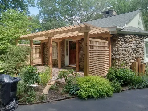 Custom pergola and lattice at a stone entry